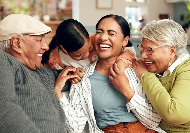 grandparents laughing with their grandkids sitting in the living room together keys to a successful retirement
