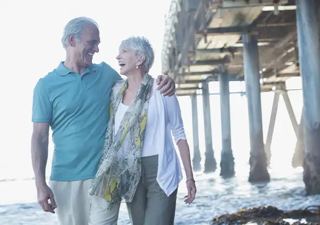 senior couple laughing near pier at beach medicare anchor pointe wealth annapolis chester maryland