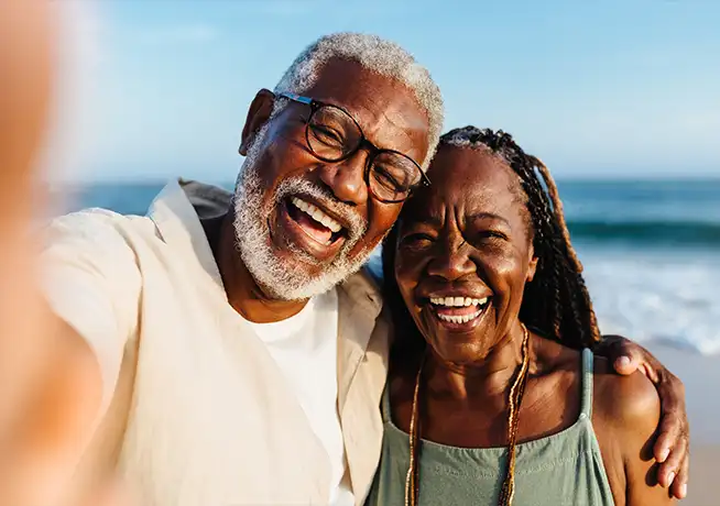 smiling senior couple enjoying beach walk long term care anchor pointe wealth annapolis chester maryland